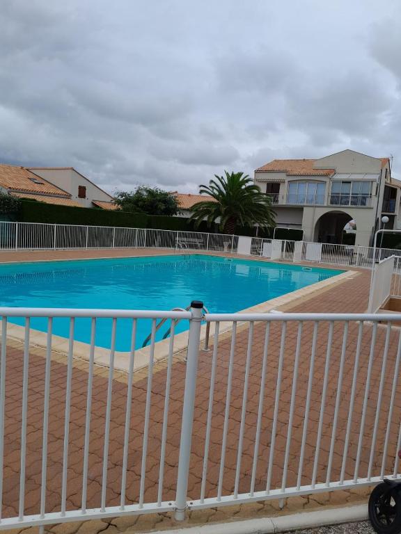 une grande piscine bleue avec une clôture blanche dans l'établissement Maison de la mer, à Vaux-sur-Mer