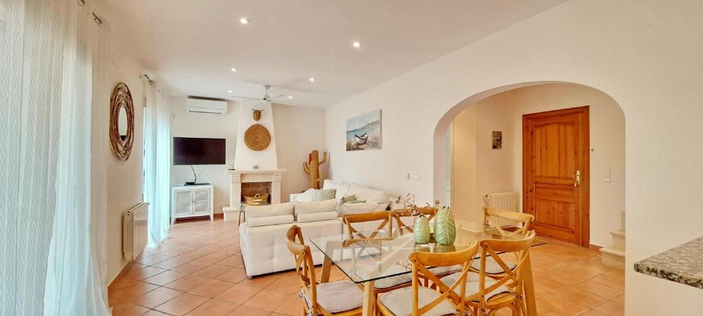 comedor y sala de estar con mesa y sillas en Villa El Encanto, en Moraira
