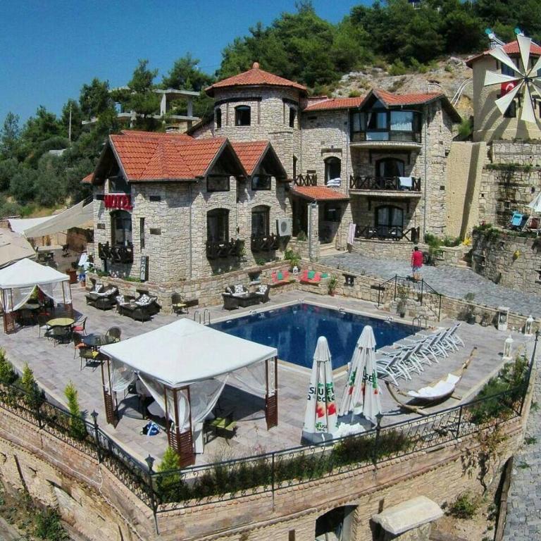 a large house with a swimming pool in front of it at The Stone Castle Boutique Hotel in Ağaçlı