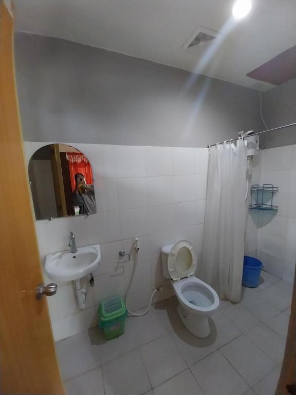uma casa de banho com um WC, um lavatório e um espelho. em TAVERN ROOMS FOR RENT em Panglao City