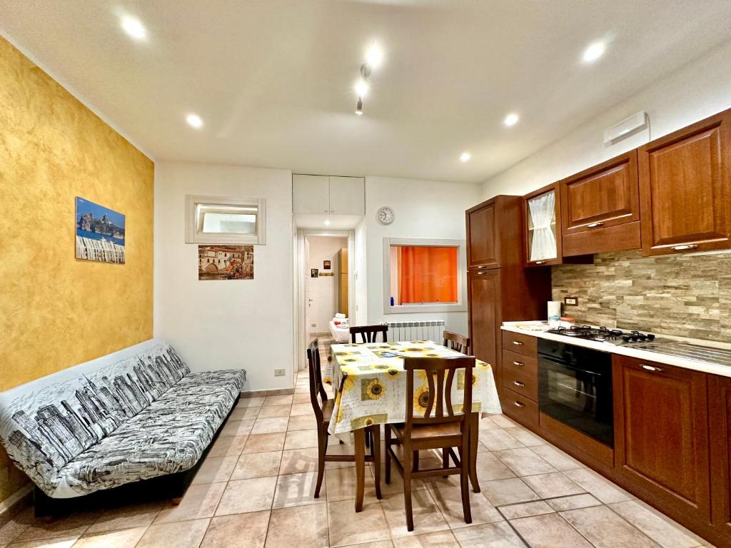 a kitchen with a table and a couch in a room at Il Rifugio Del Marinaio By Housilia in Cefalù