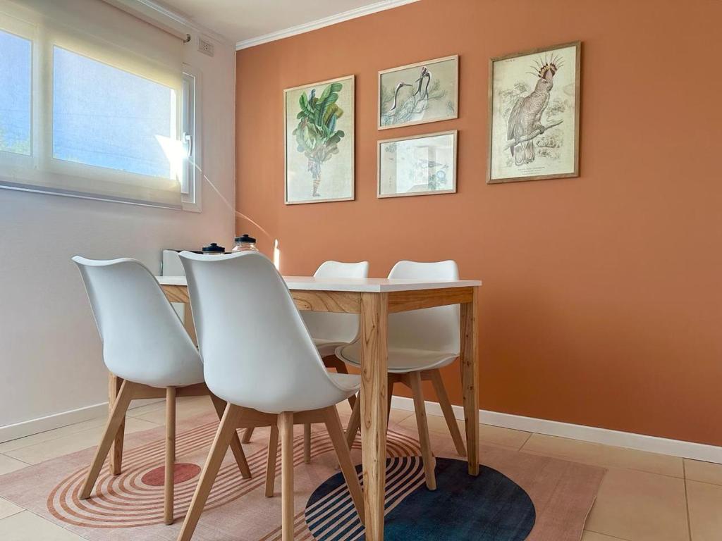ein Esszimmer mit einem Holztisch und weißen Stühlen in der Unterkunft Duplex zona calvario in Tandil