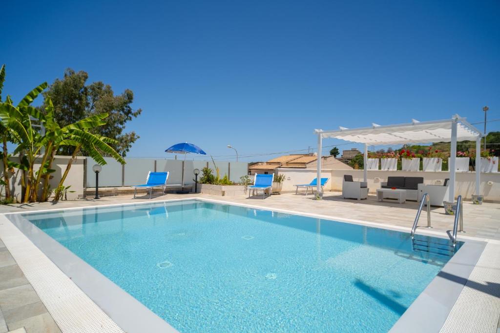 une grande piscine avec des chaises bleues dans l'établissement holiday inn endless summer, à Alcamo