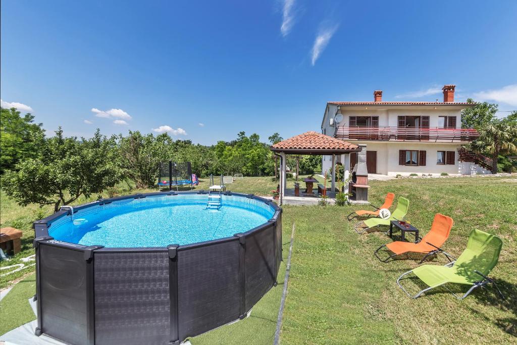 ein Pool mit Stühlen und ein Haus im Hintergrund in der Unterkunft House FELICIA in Kršan