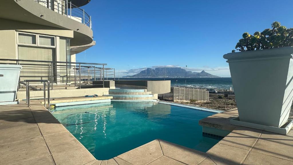 a swimming pool on the side of a building at Oceansnest Guest House in Bloubergstrand