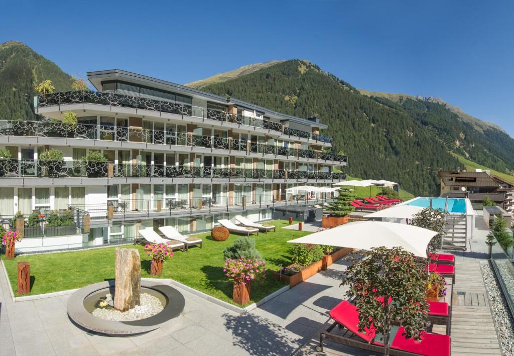 a hotel with a courtyard with a mountain in the background at Hotel Fliana 4-Sterne Superior in Ischgl