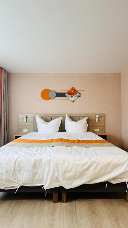 1 dormitorio con 1 cama grande con sábanas y almohadas blancas en Hotel Libers, en Lauterbach
