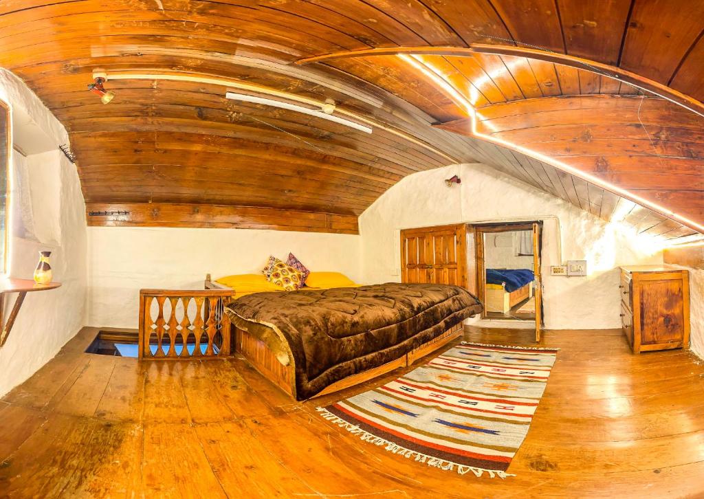 um quarto com uma cama grande e um tecto de madeira em Aarya homes em Manali