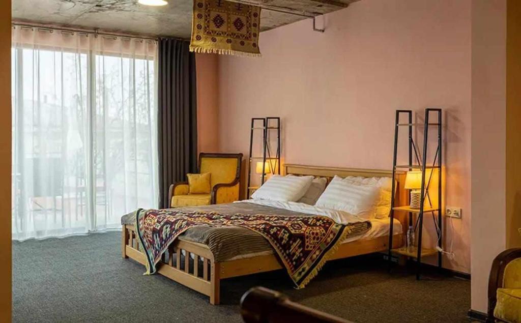 ein Schlafzimmer mit einem Bett, einem Stuhl und einem Fenster in der Unterkunft Paradiso Hotel in Telawi