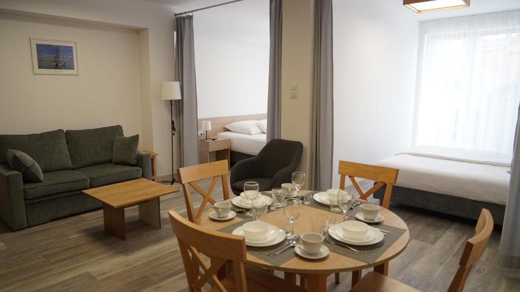 sala de estar con mesa, sillas y sofá en Aparthotel Passage en Giżycko