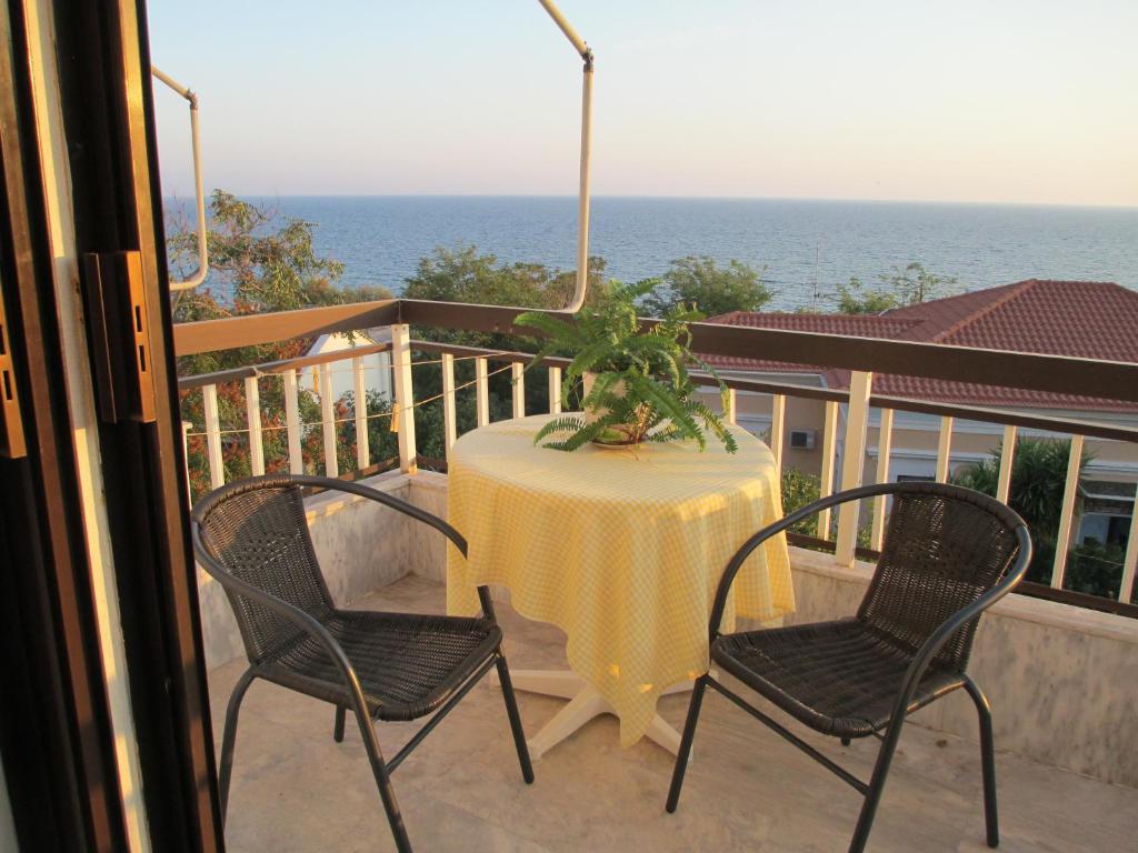 a table and chairs on a balcony with the ocean at Nick House in Plomari