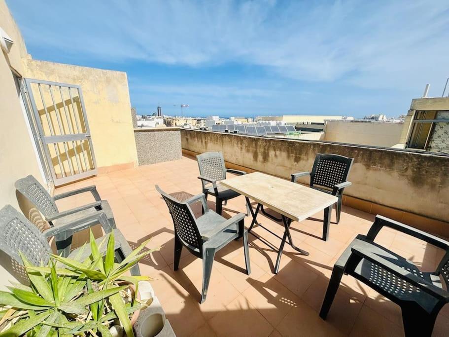 eine Terrasse mit einem Tisch und Stühlen auf dem Balkon in der Unterkunft 2 bedroom 2 bathroom Apartment in Sliema