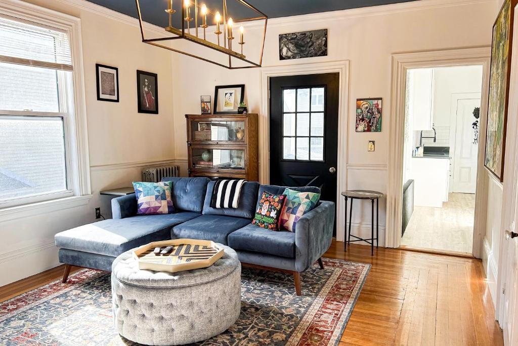 a living room with a blue couch and a table at Witchy Modern in Salem