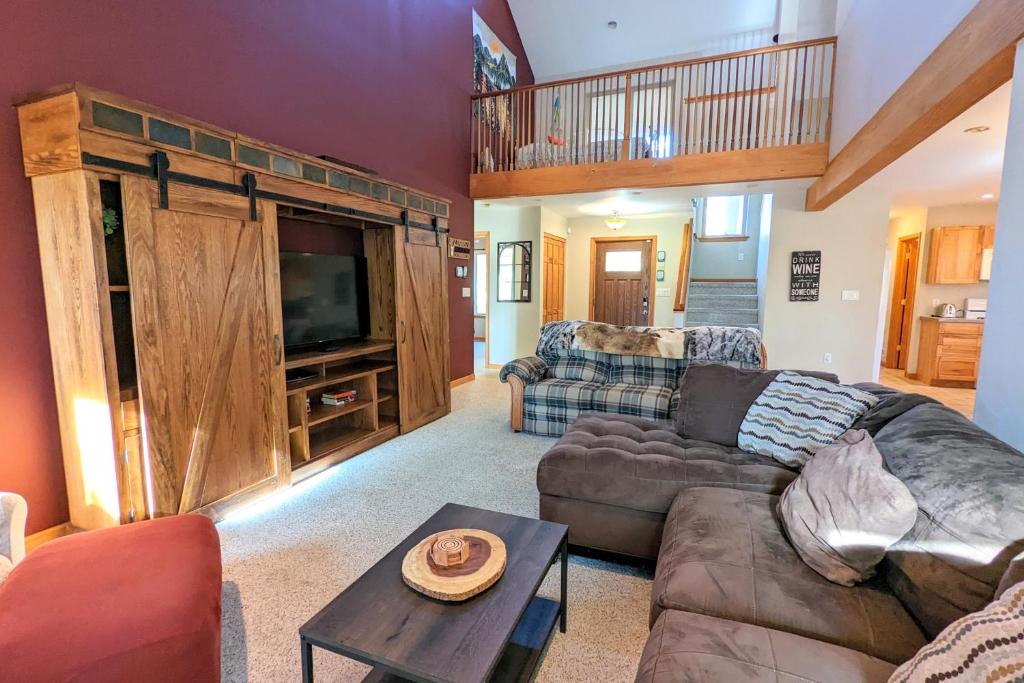 ein Wohnzimmer mit einem Sofa und einem TV in der Unterkunft Mountain Hideout by AvantStay Game Room Deck in Albrightsville