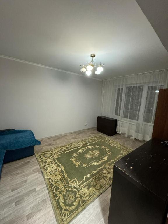 una sala de estar vacía con una alfombra en el suelo en Квартира Аэропорт, en Turksib