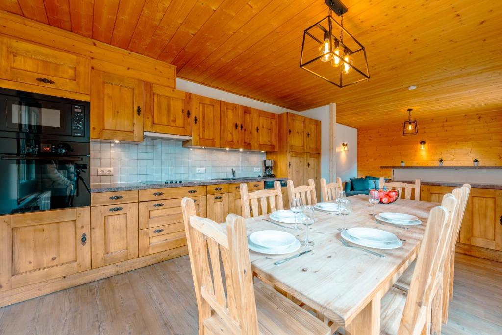 a dining room with a table and a kitchen at Etoile des Vents in Morzine