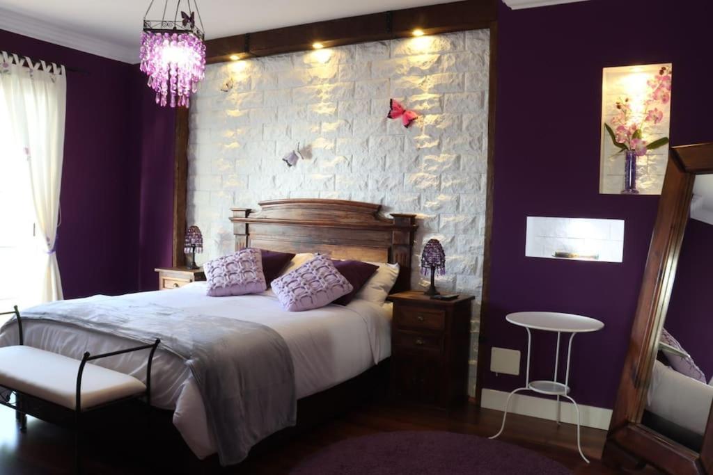 a bedroom with a large bed with purple walls at Casa amplia - Ideal para familias, terraza y relax in La Victoria de Acentejo