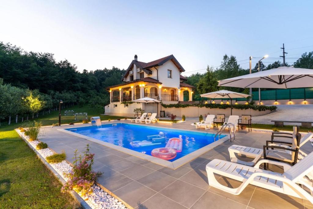 a house with a swimming pool in front of a house at Vila Sarajevo in Sarajevo