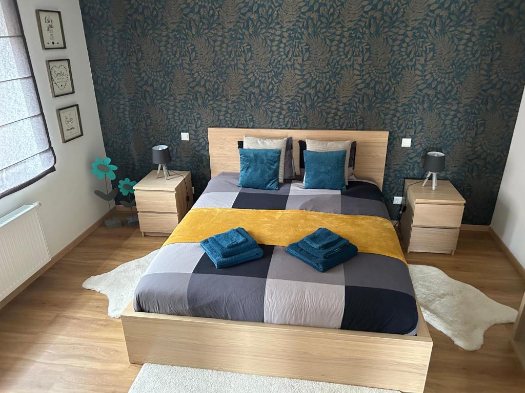 1 dormitorio con 1 cama grande con almohadas azules en Le cocon de Céline, en Eischen