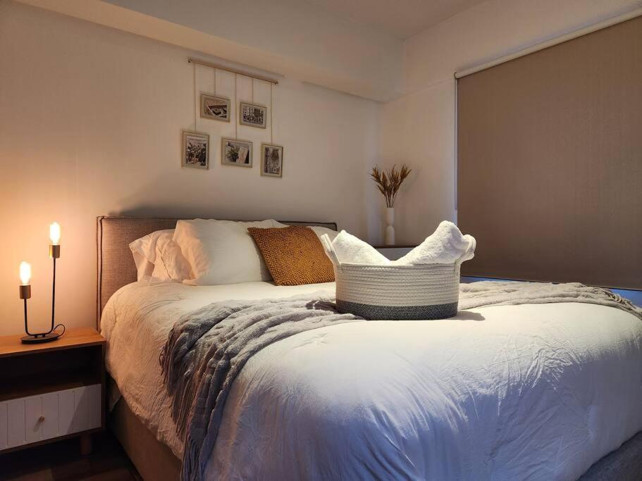 Un dormitorio con una cama grande y una mesa con una lámpara. en La Floresta en Quetzaltenango