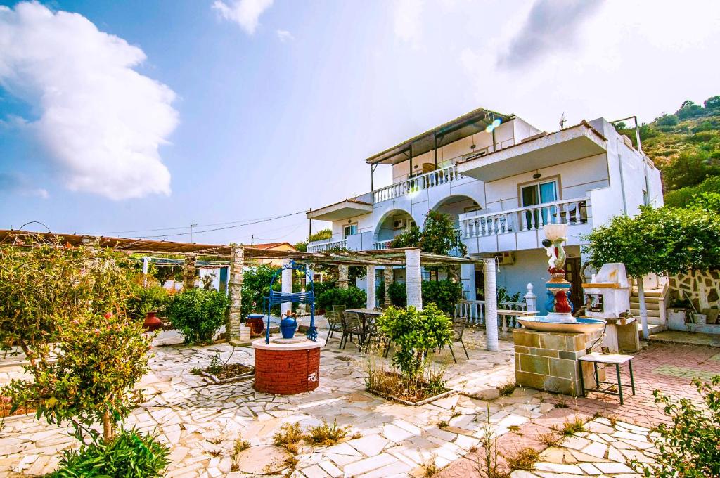 Una gran casa blanca con un patio enfrente. en Irene Apartments, en Karpathos