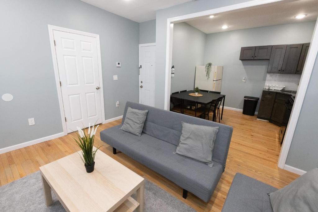 - un salon avec un canapé bleu et une table dans l'établissement Cozy & Classy 3-Bed to mins NYC, à Jersey City