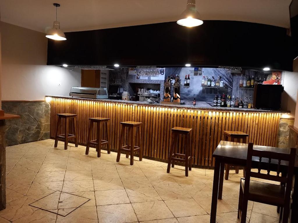 a bar with a row of stools in a restaurant at HOTEL RURAL ORQUIDEA in Velilla del Río Carrión