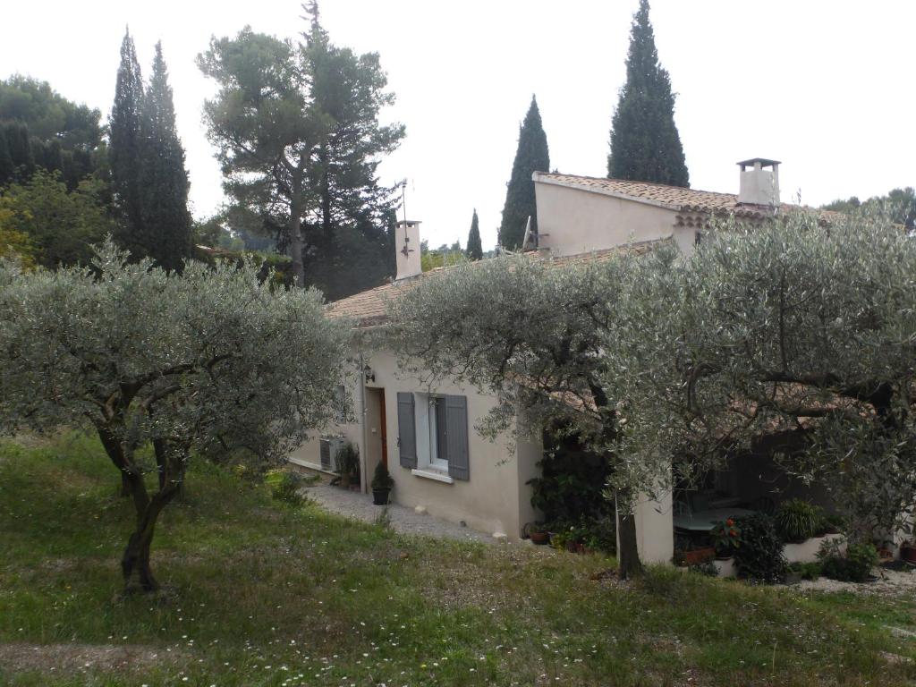 a white house with trees in front of it at 2 chambres au calme Villa Chrisma Provence in Orgon