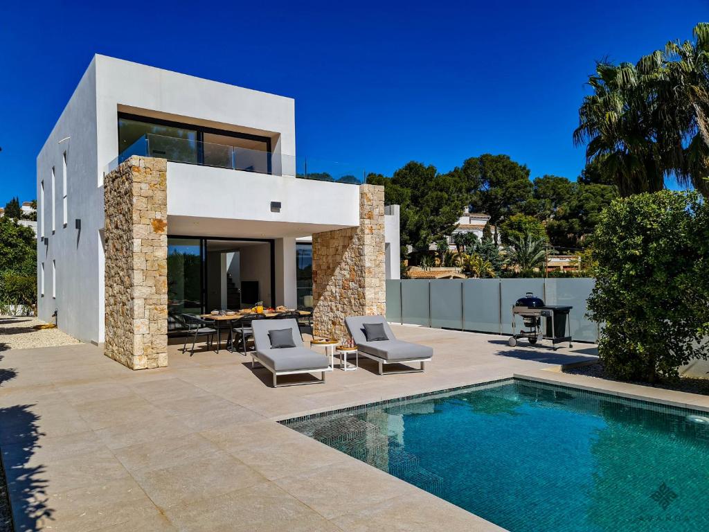 uma villa com uma piscina e uma casa em Villa moderna de lujo de nueva construcción a 1km de Playa Fustera - Ref A014 AVANOA PREMIUM RENTALS em Benissa