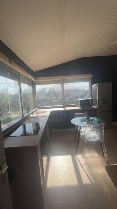 eine Küche mit einem Schreibtisch und einem Tisch in einem Zimmer in der Unterkunft Agréable T2 proche Toulouse in Léguevin