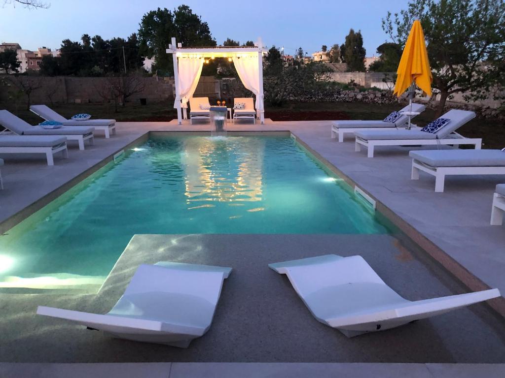 - une piscine avec des chaises longues et un kiosque dans l'établissement CasaKarina - Villa con piscina privata, à Specchia