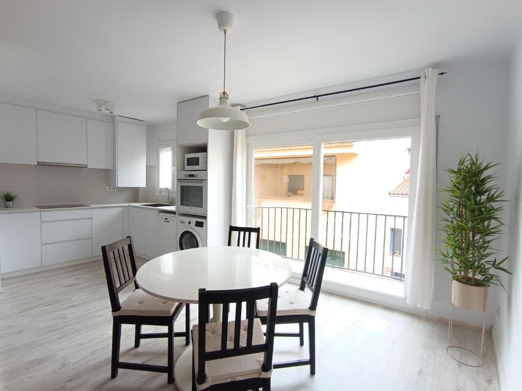 a kitchen and dining room with a table and chairs at Aiguaneu S'Auguer in Blanes