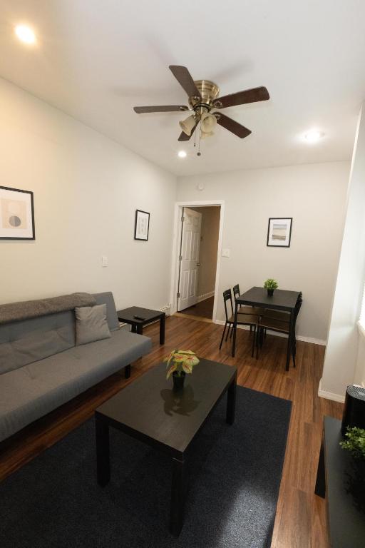 uma sala de estar com um sofá e uma ventoinha de tecto em Chic 3BR Hideaway mins from NYC em Jersey City