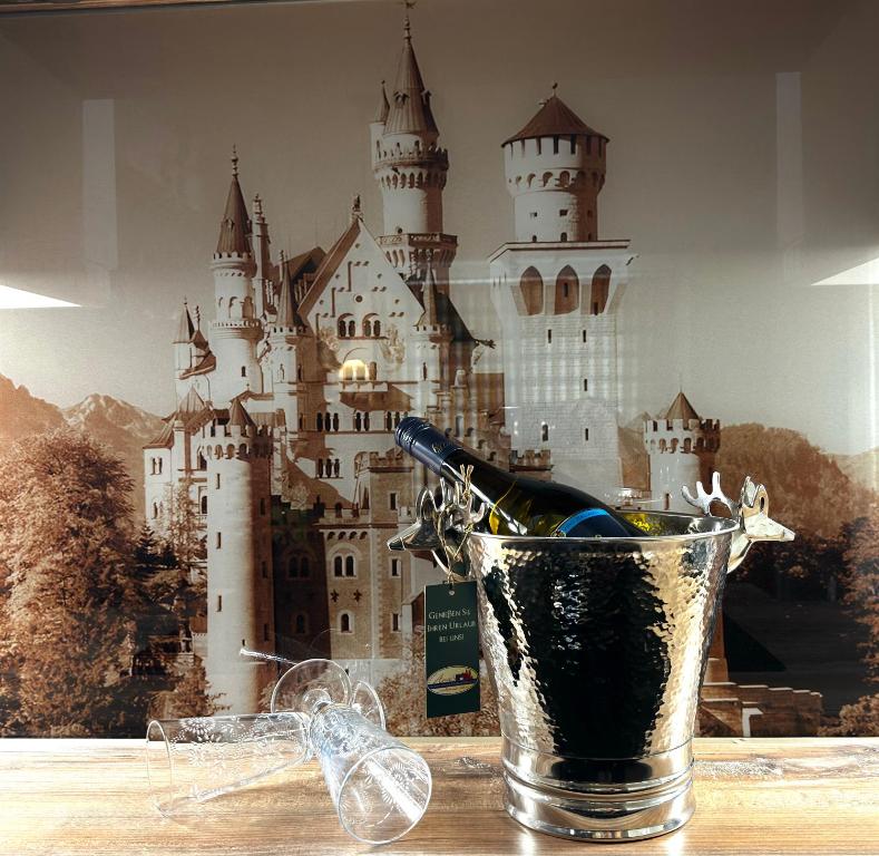 eine Flasche Wein im Glas mit einem Schloss in der Unterkunft Ferienwohnung-Königsschlösser in Füssen