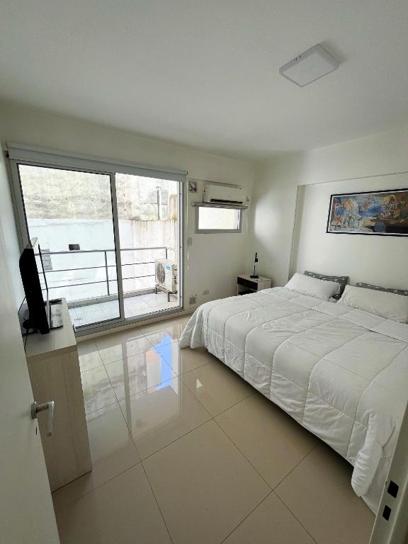 um quarto com uma cama grande e uma janela grande em Luminoso departamento en Villa Crespo em Buenos Aires