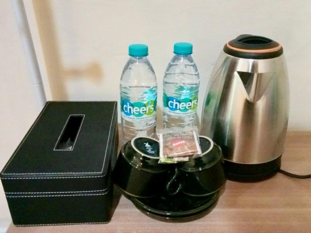 zwei Flaschen Wasser neben einer Kaffeemaschine in der Unterkunft Kelud Syariah Guesthouse in Blitar