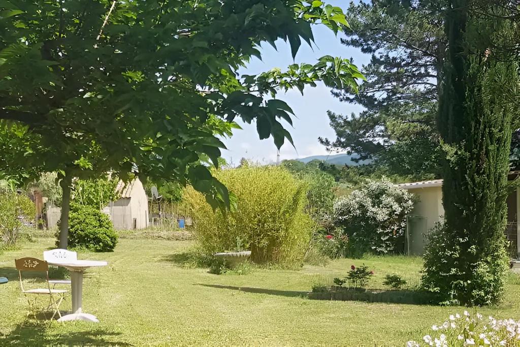 un giardino con tavolo in erba di Chambre dans Petit havre de paix avec piscine chauffée au coeur du Luberon a Gargas