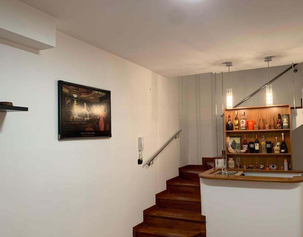 una habitación con una escalera con un bar y algunas botellas de vino en Casa l'Orologio, en Barletta