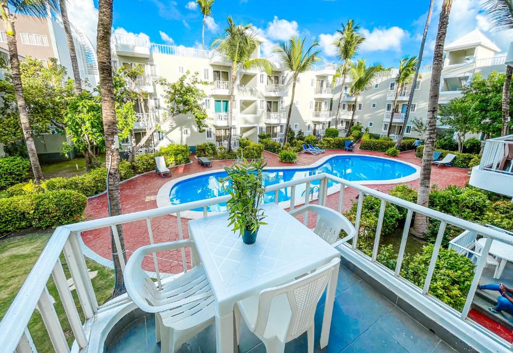 uma varanda com uma mesa e cadeiras e uma piscina em BAVARO Los Corales SOL Caribe STUDIOS Rooms DELUXE WiFi Parking BEACH CLUB & SPA em Punta Cana