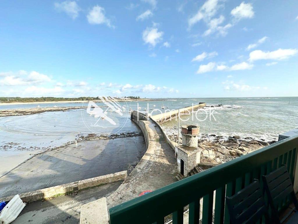 een vogel die over een strand vliegt met de oceaan bij EXCEPTIONNEL ! T3 Duplex – Vue mer 180° sur le port de Lomener in Ploemeur