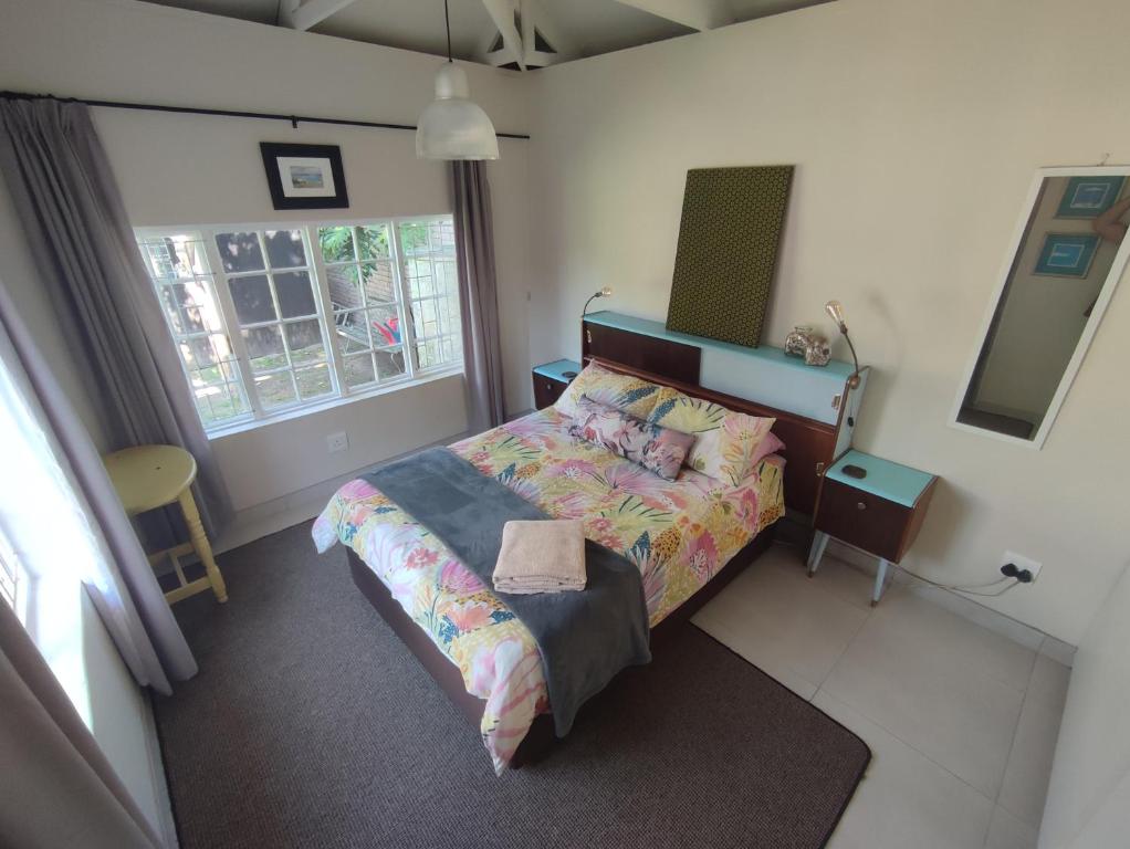 a bedroom with a bed and a window at Paradise in the City - Cottage One in Port Elizabeth