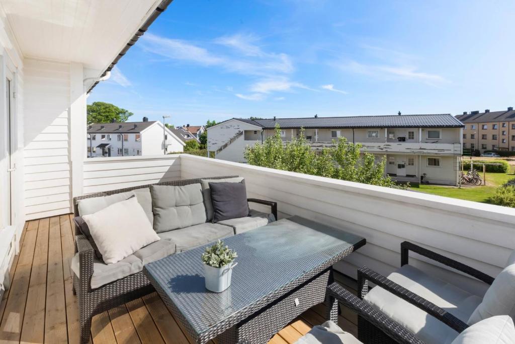 a patio with a couch and a table on a balcony at Lund Apartment in Kristiansand