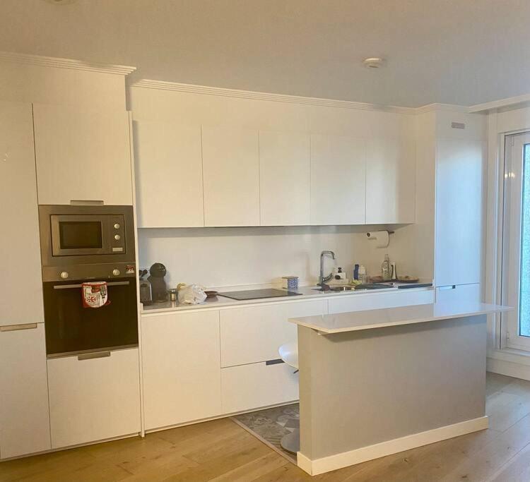 a kitchen with white cabinets and a black microwave at preciosa casa,garage wifi 4 personas in Vigo