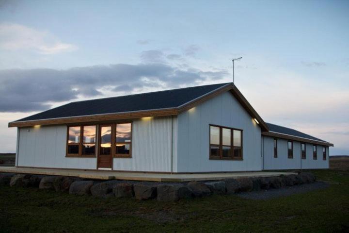 a small white house with a black roof at Myrkholt Cabin in Selfoss