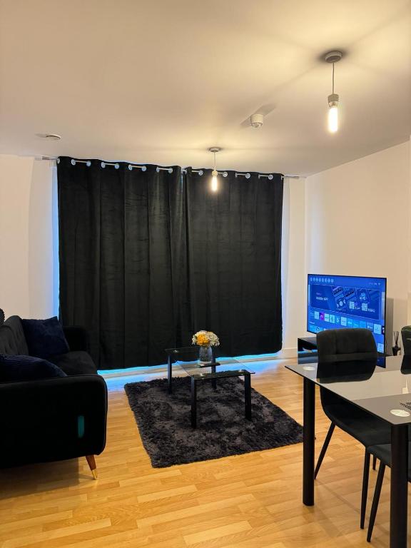 a living room with a couch and a table at Spacious 2 Bedrooms Apartment In Stratford in London