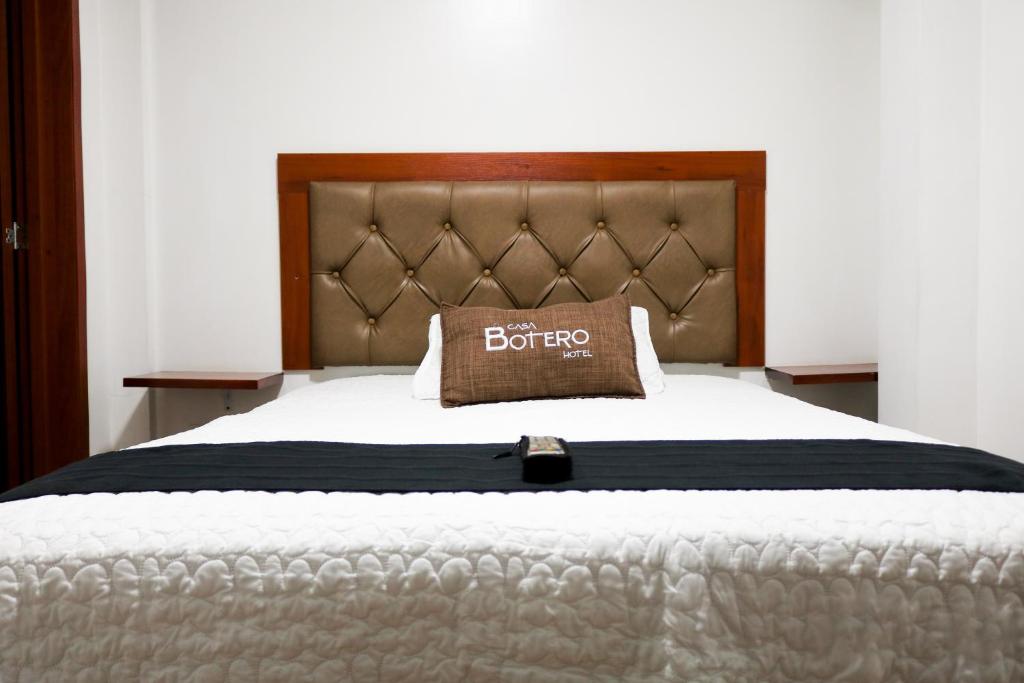 a bed with a brown pillow on top of it at Hotel Casa botero 106 in Bogotá