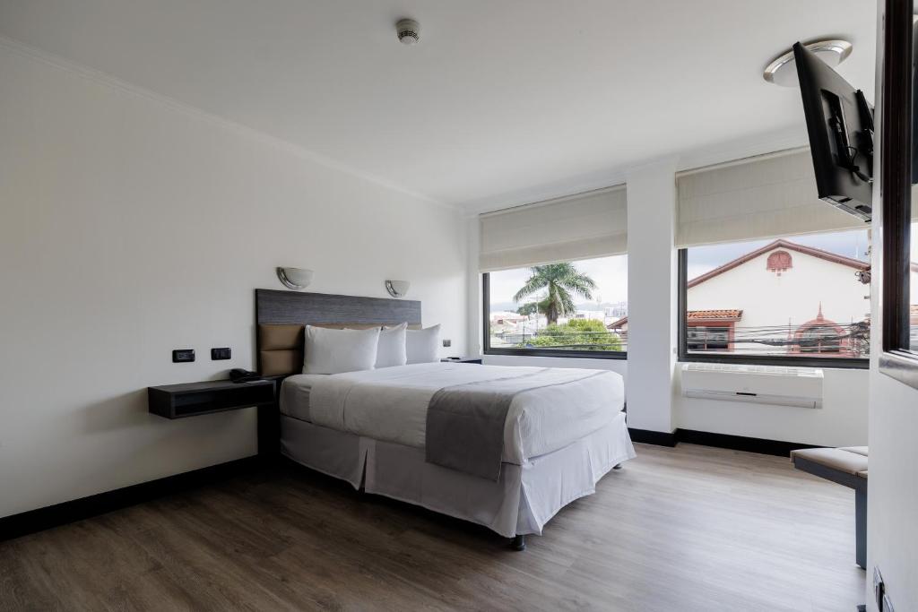1 dormitorio con cama grande y ventana grande en Parque del Lago Boutique Hotel, en San José