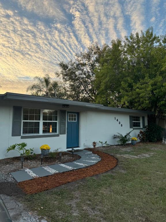 uma pequena casa branca com uma porta azul em Clearwater Creek Home in Superb Location em Clearwater