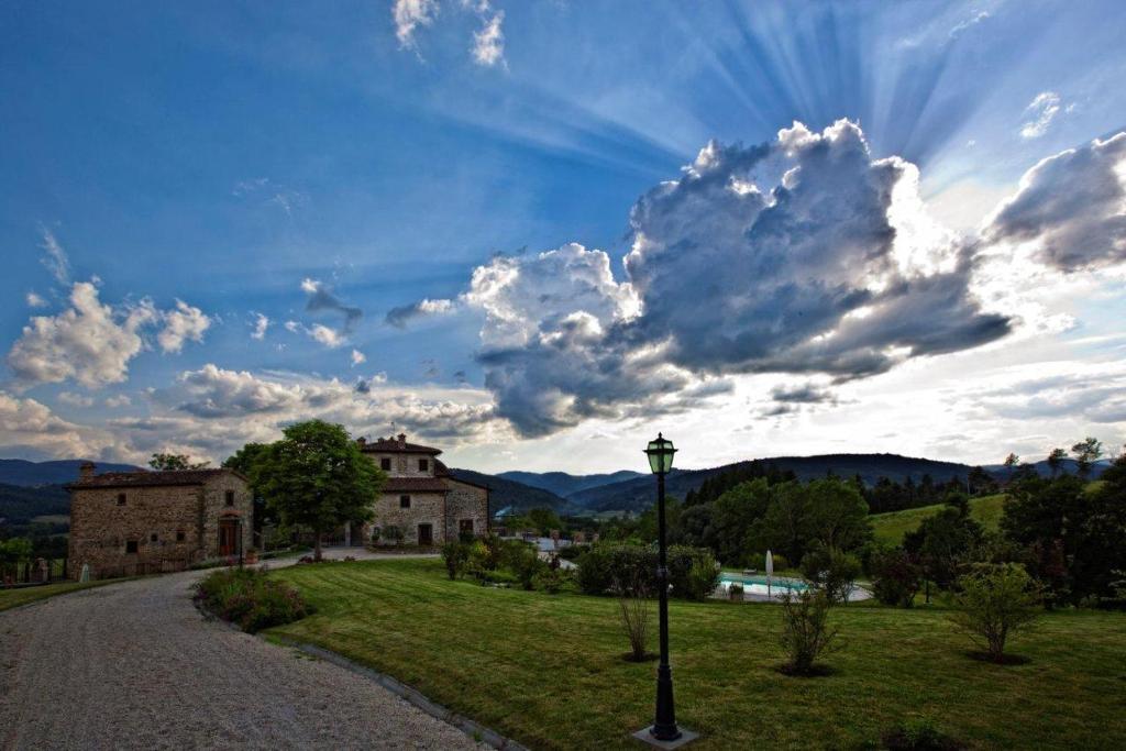 a cloudy sky with a building and a street light at Il Cardo Resort in Anghiari