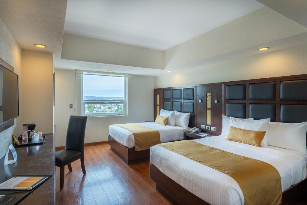 プエブラにあるComfort Inn Puebla Centro Historicoのベッド2台と窓が備わるホテルルームです。